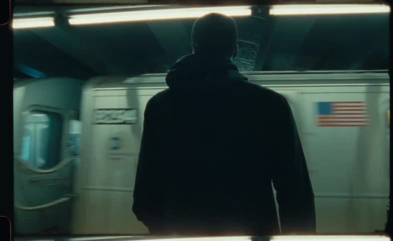 A black man is watching a subway train go by