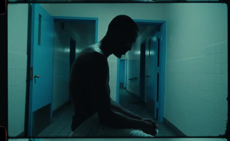 A man is sitting on a bench in an empty room