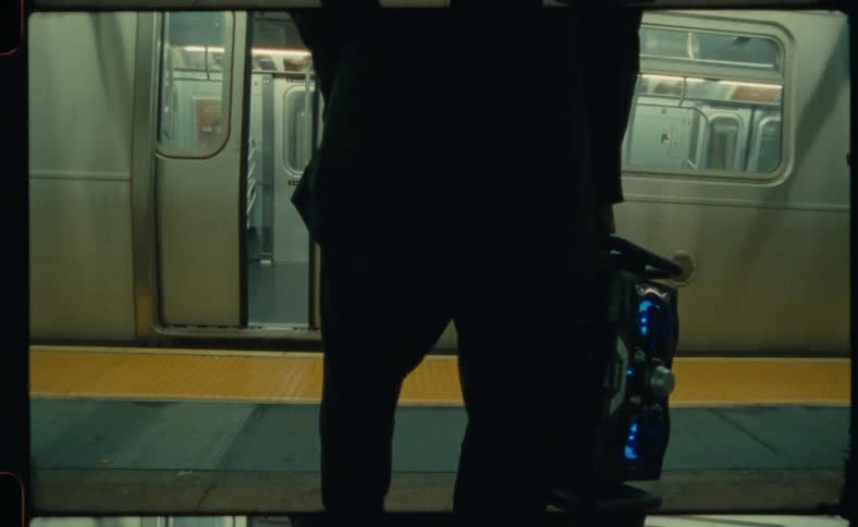 Man carries a large speaker onto an empty train