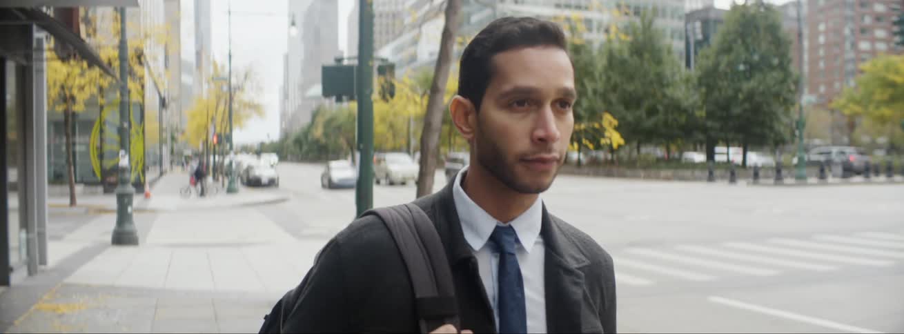 Businessman with tie and shirt walks down the street in the city