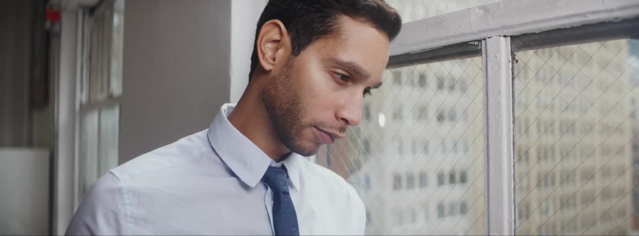 A man is standing in a room next to a window