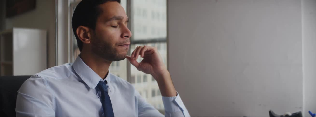 Frustrated man working on laptop in an office building