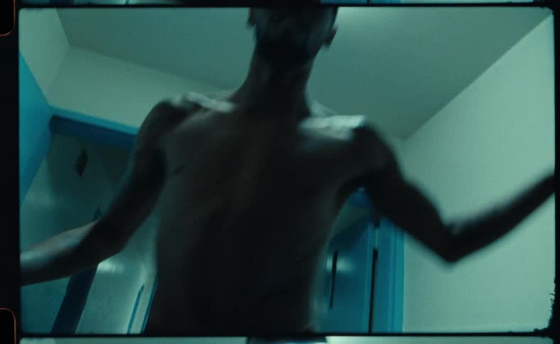 A man is dancing indoors near an open door