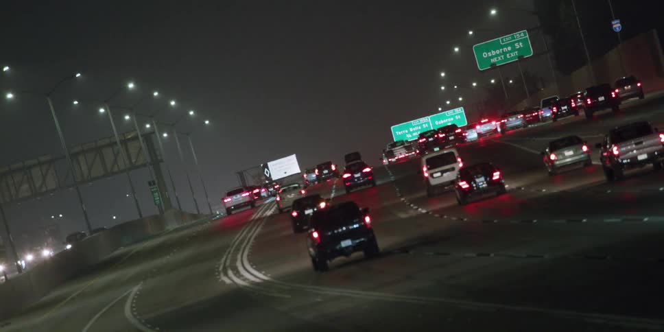 Heavy traffic moves on a foggy highway at night