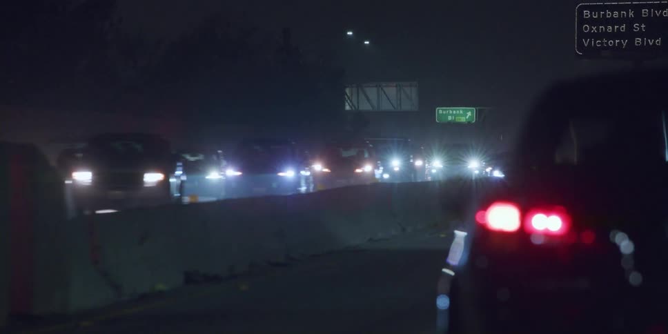 Traffic is moving on the highway at night