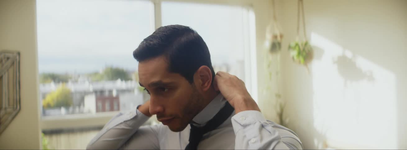 Businessman ties tie on balcony