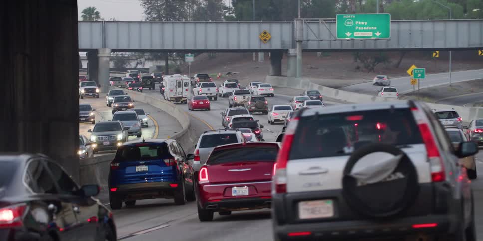 Heavy traffic on a highway as automobiles travel under bridges along the road
