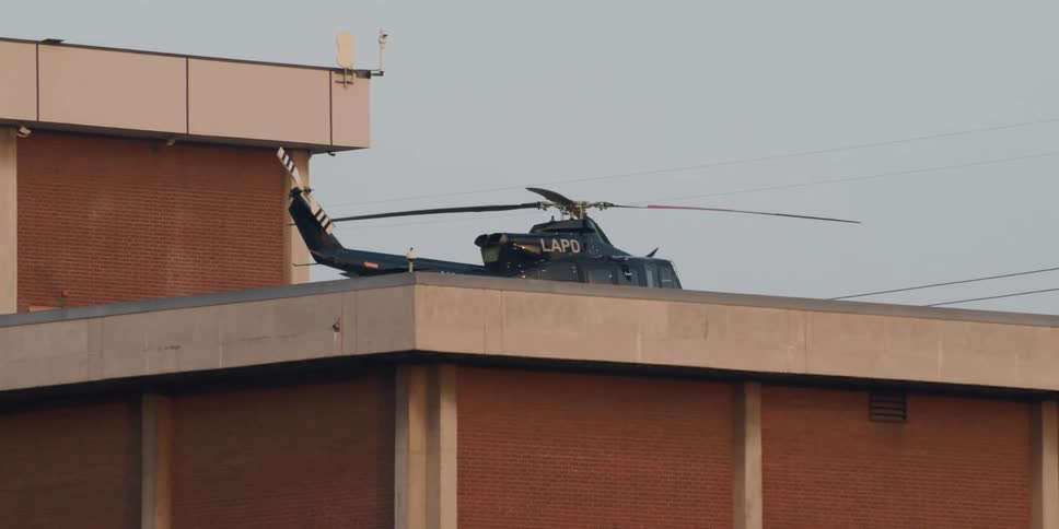 Black police helicopter sits on a rooftop