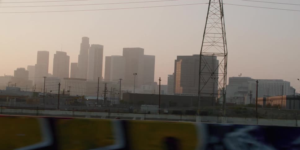 Big city skyline with high rise buildings seen from a running train at sunrise