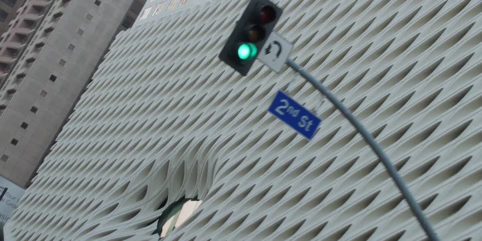 Cars and people are walking in a city with tall buildings