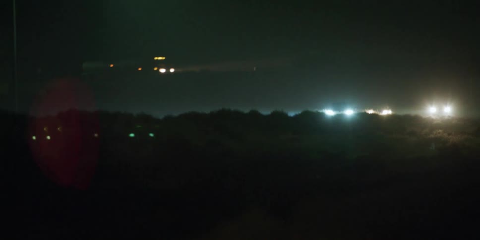 Cars are driving on a street at night