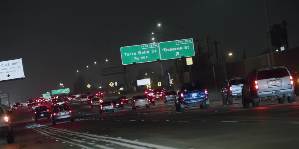 Traffic on a busy highway at night moves slowly