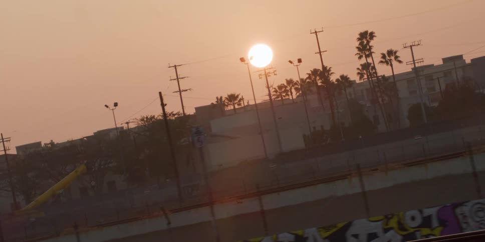 The sun is setting in a downtown city