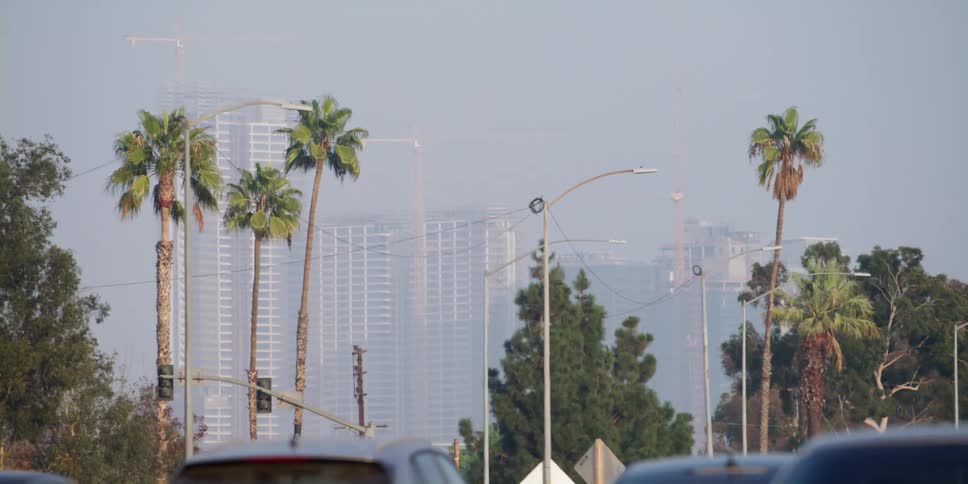 High rise city buildings in fog seen from moving car on highway