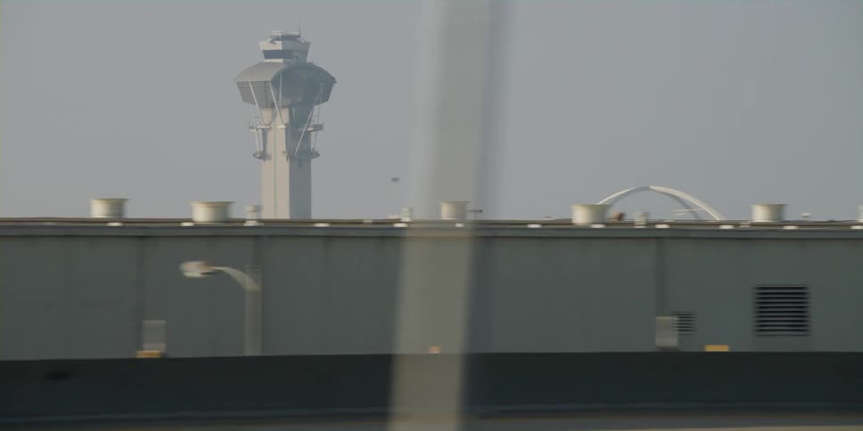 Cars are driving on a highway on the outskirts of a city