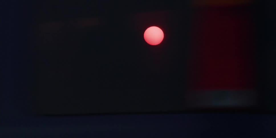 Cars and trucks are parked near utility towers as the sun is shining brightly in the sky above buildings