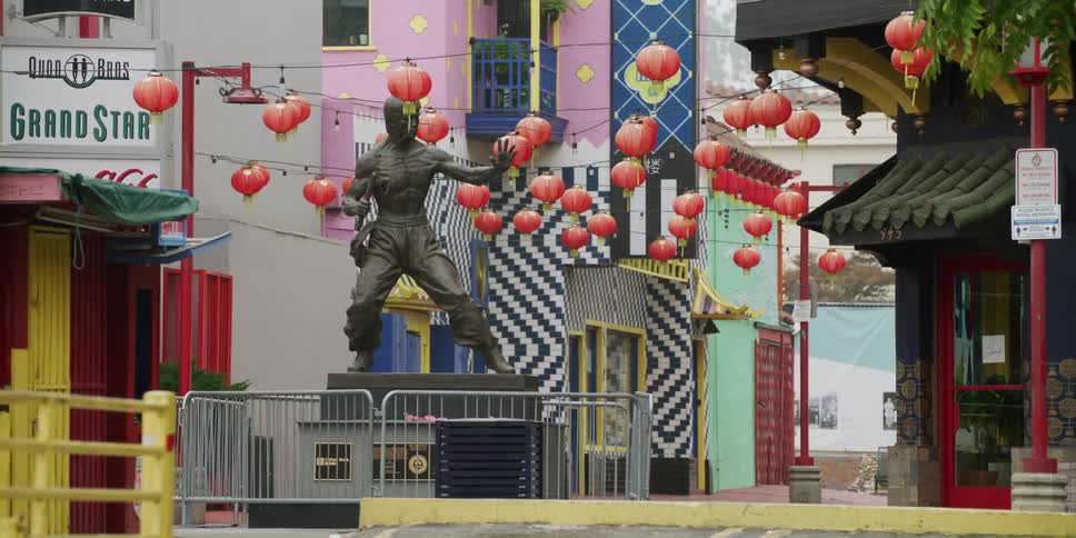 A statue of a martial artist sits just off the city street