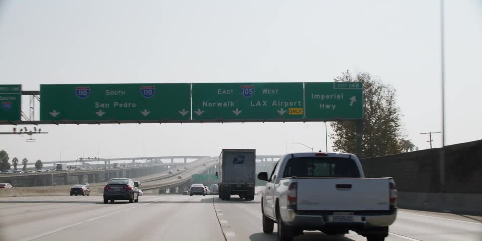 Cars and trucks travel on a highway in light traffic