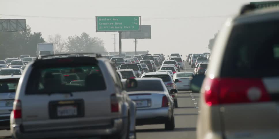 Heavy traffic travels on the highway near the trees