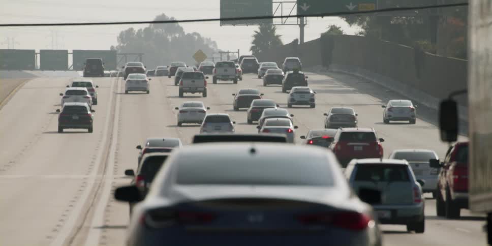 Cars are driving down a highway in spring