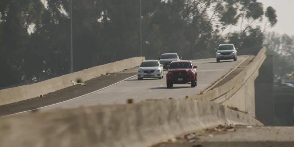 Vehicles drive on a multi lane highway overpass