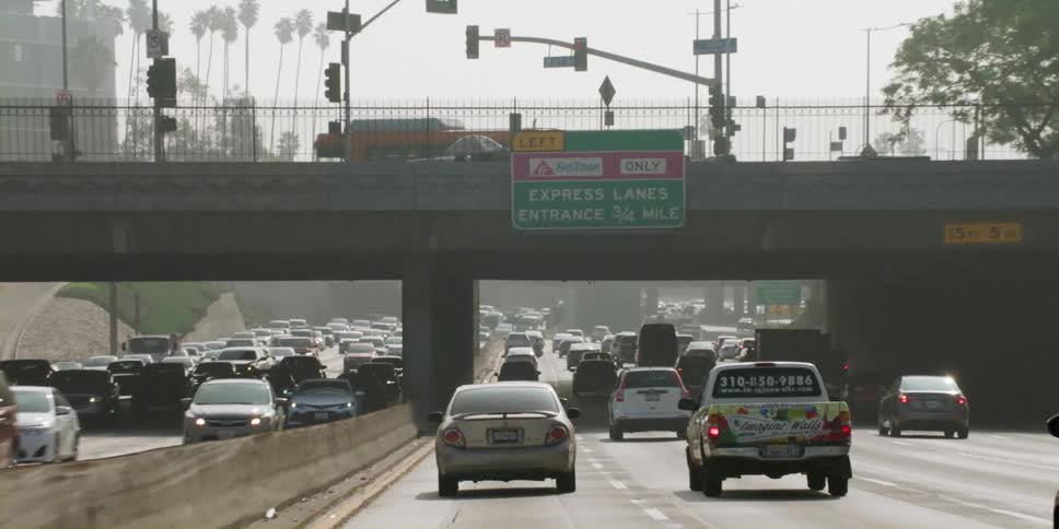 Cars driving at a busy highway in the middle of the day