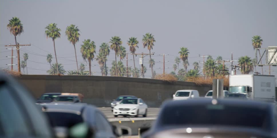 Cars are driving on a divided highway in spring