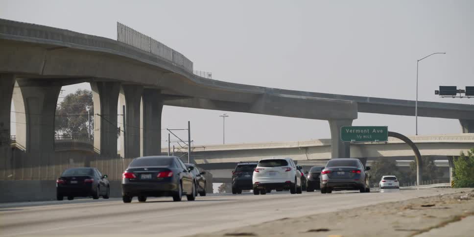 Traffic on a highway as automobiles travel under a bridge