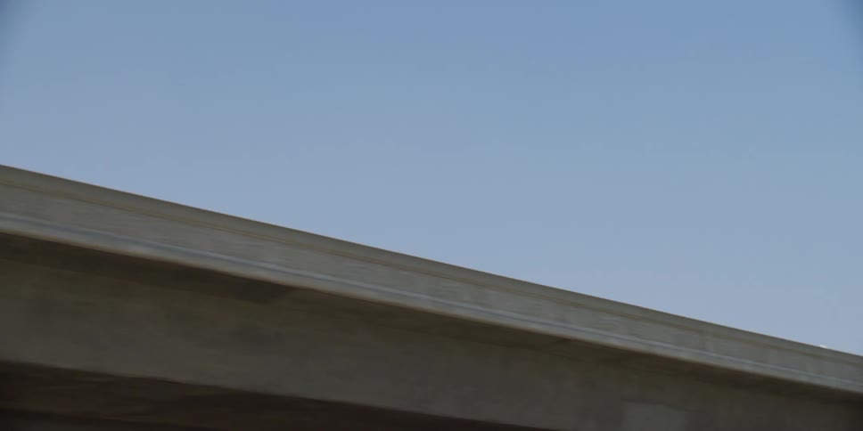 A bus and cars driving by overpasses in a city