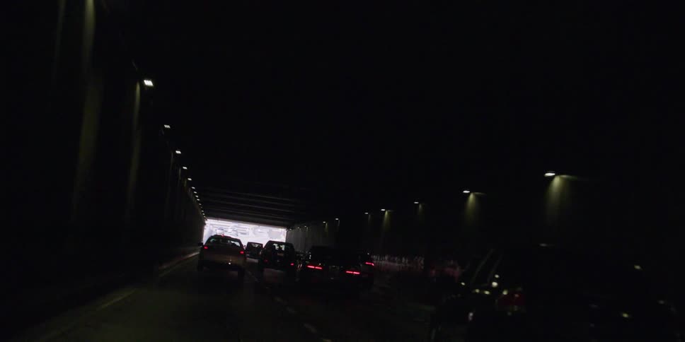 Cars are driving through a tunnel in the daytime