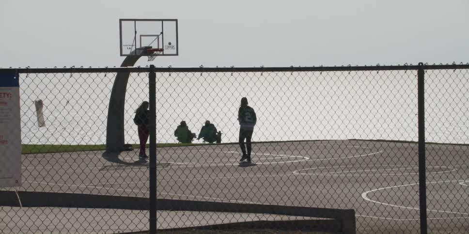 People are playing basketball on the court