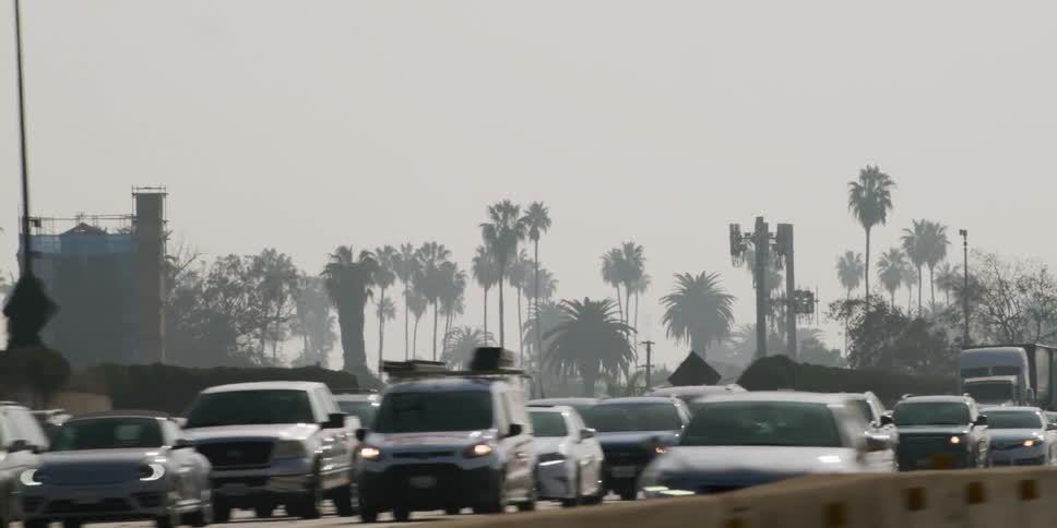 Heavy traffic flows along divided highway on foggy day