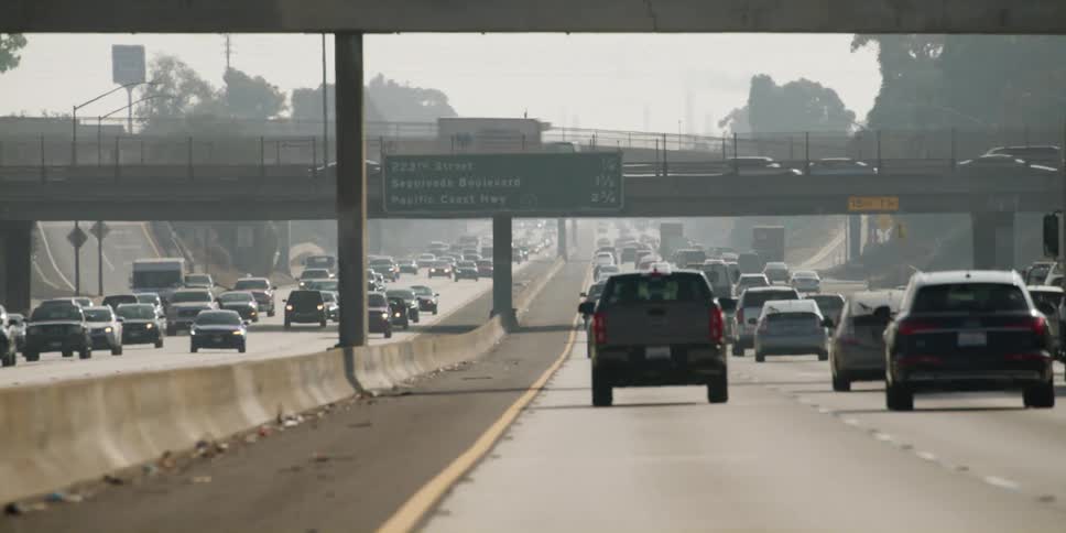 Automobiles travel on a highway in busy traffic