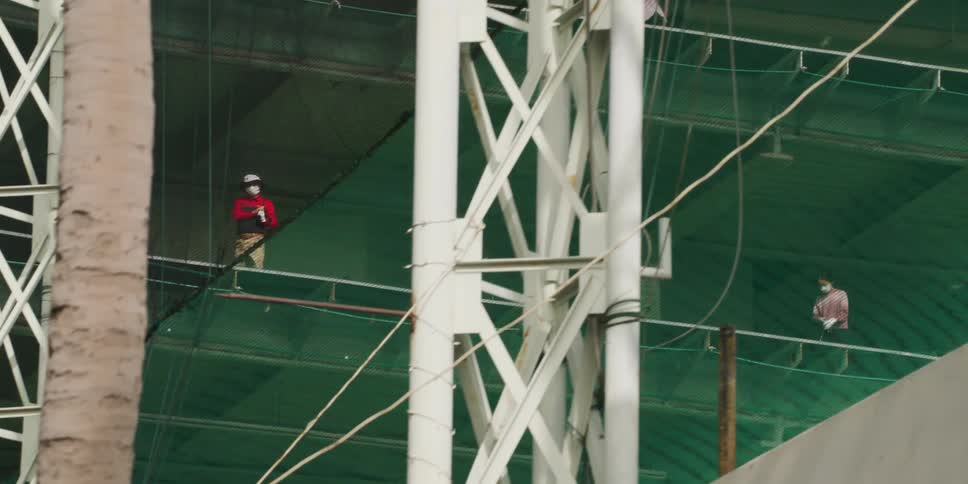 Two men drive the ball at a driving range