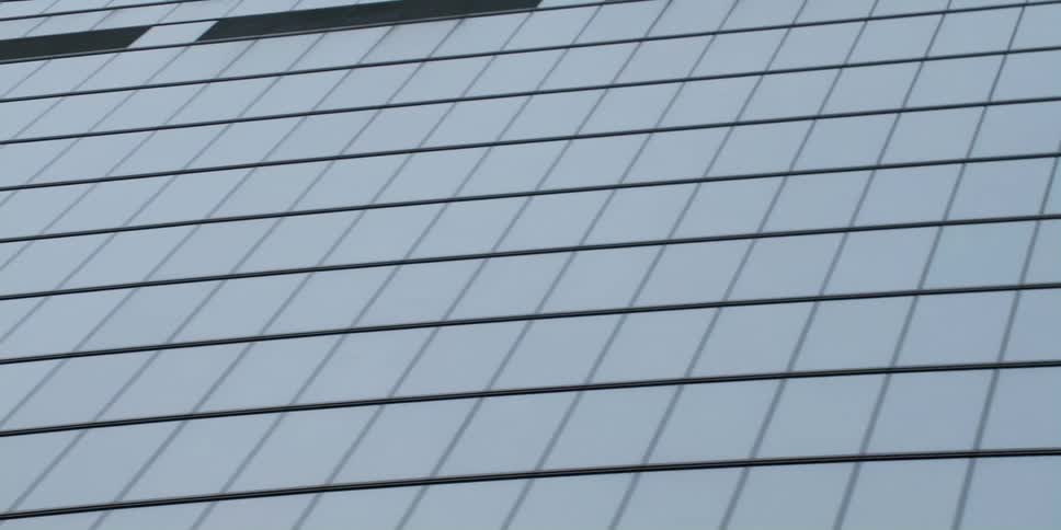 The glass facade of a skyscraper on a gray day