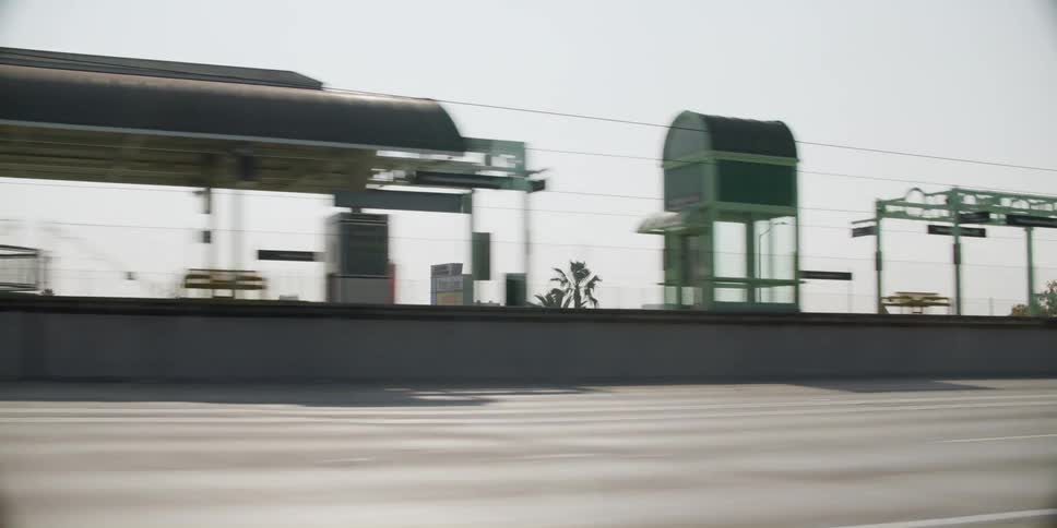 Vehicles drive along highway passing transit stations