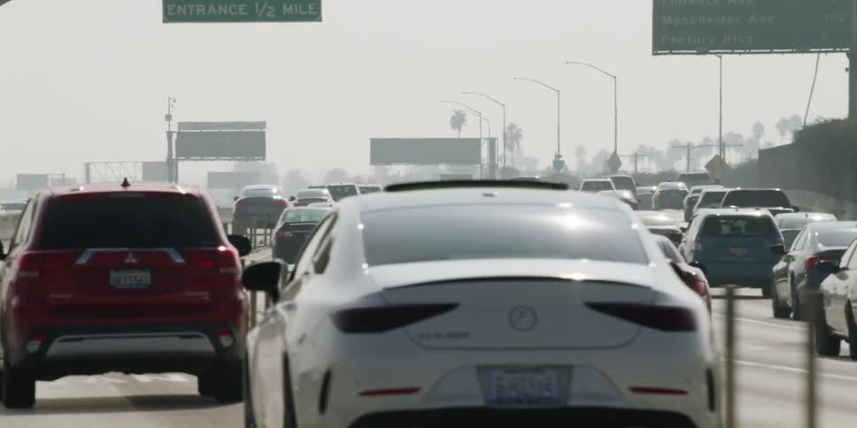 Cars are driving on a highway near a city