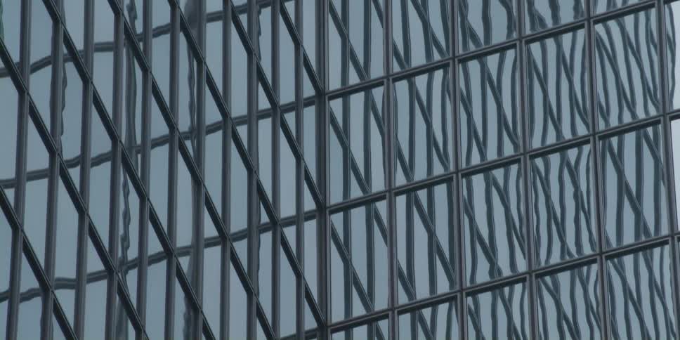 Blue skies reflect off the mirror surface of a skyscraper