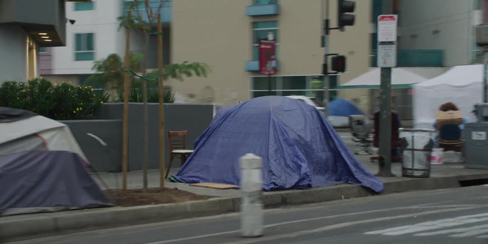 A line of tents for homeless people line the city street