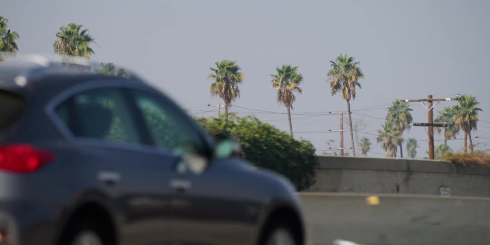 Bumper to bumper traffic passes through a city on a multi lane highway