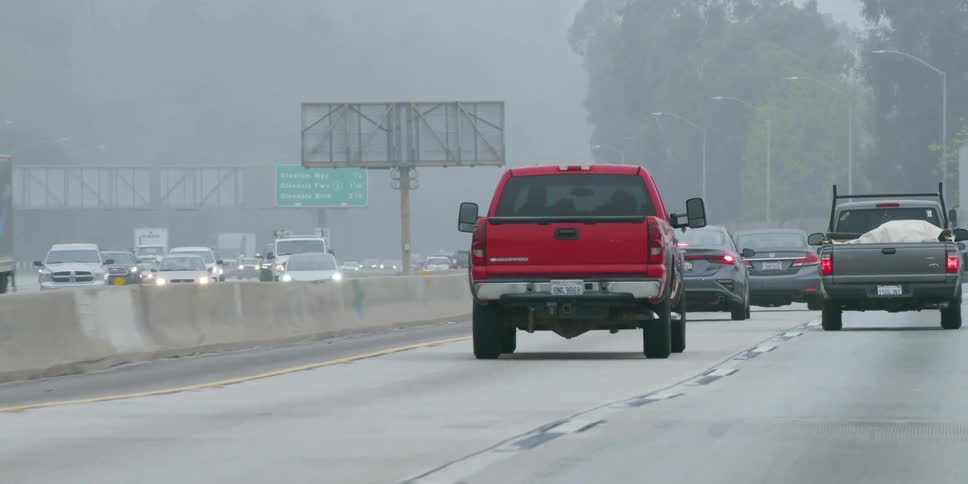 Busy traffic moves slowly on a foggy highway