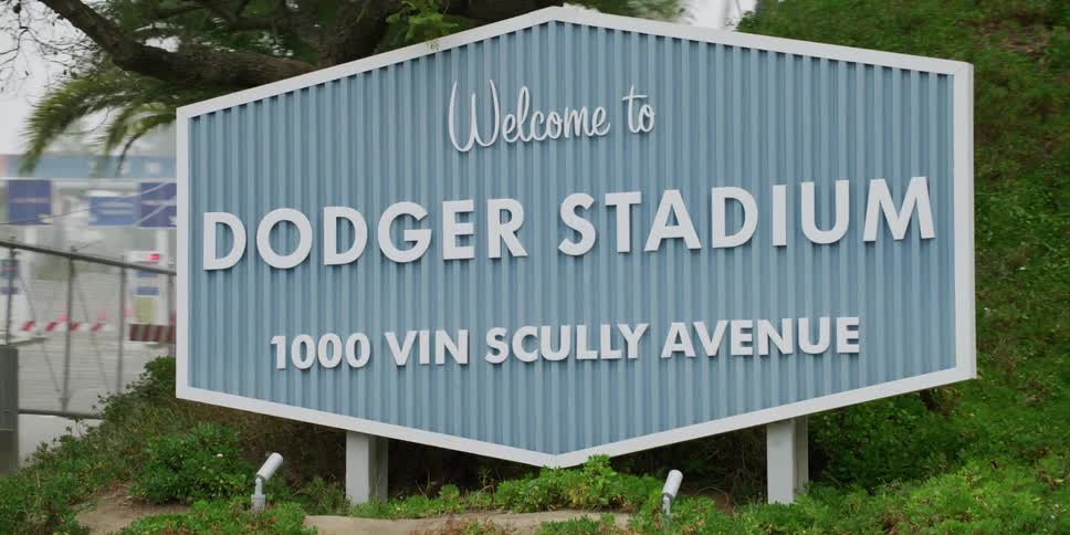 A sign sticks out for the baseball stadium by the city street