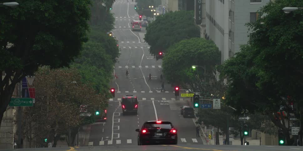 Downtown street of a big city with cars driving by and pedestrians crossing it