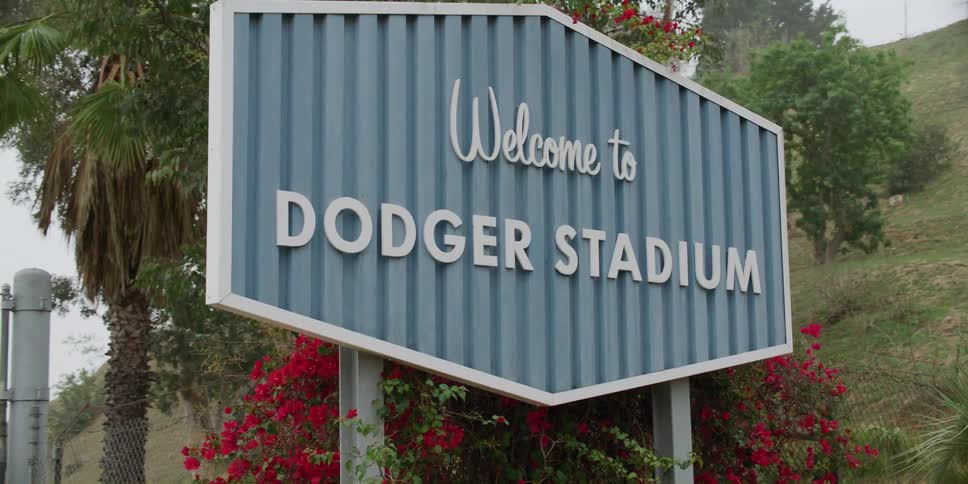 A sign in front of a fenced in stadium