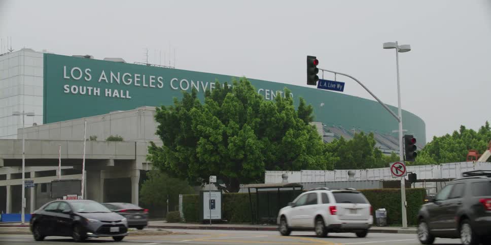 Cars driving past a convention center in a city