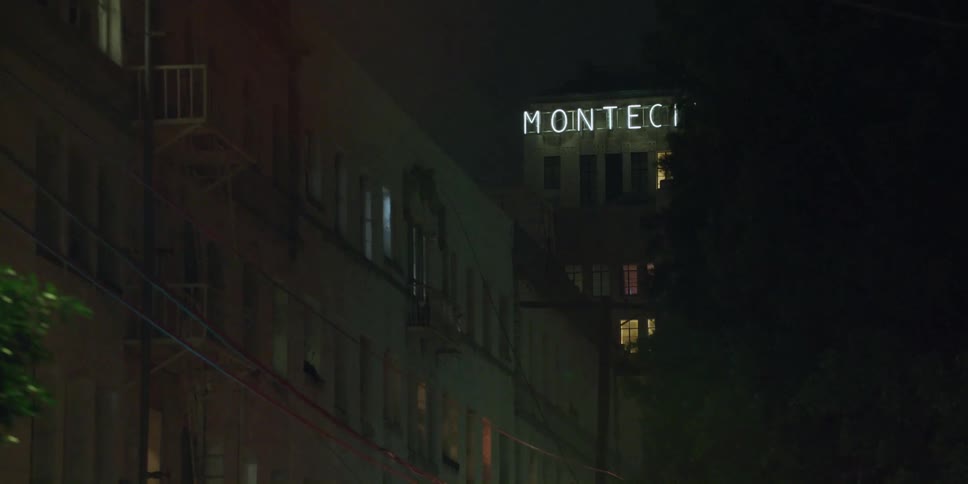 An apartment building next to a hotel in a city