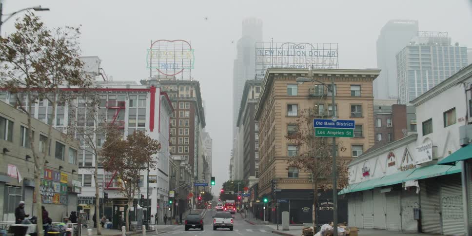 Vehicles and pedestrians commute on the city streets on a cloudy day