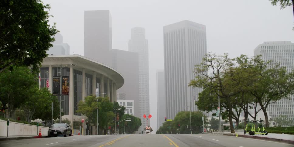 A shot of a city street with multiple high rise buildings visible at a distance