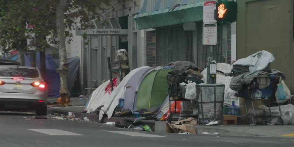 A street corner filled with tents and shopping carts filled with debris