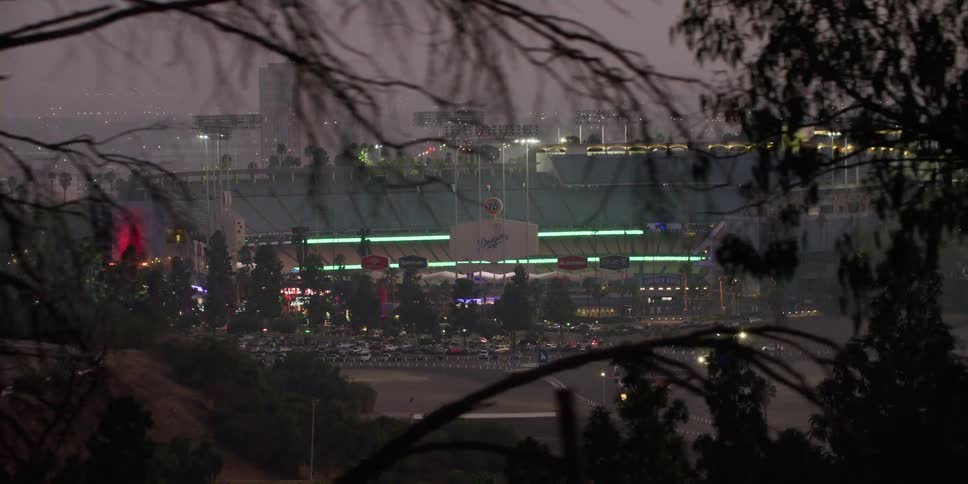 Lights from the sports arena light up the city as vehicles travel by